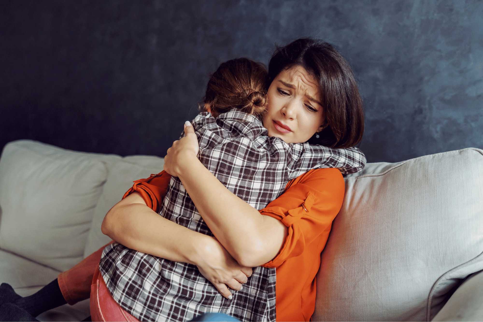 Mother hugging her son with autism during an emotional crisis at home, applying techniques on how to manage emotions step by step to regain calm in minutes.